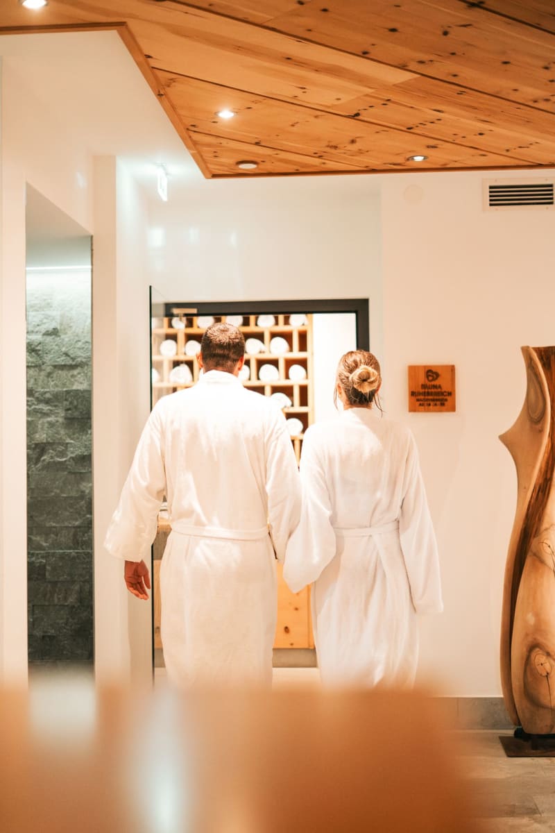 Two people relaxingly enter the wellness area in Glemmtalerhof in Hinterglemm.