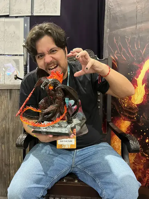 CEO da D20 Culture, Peterson Rodrigues, segura miniatura de dragão em divulgação do Entropia RPG Playtest.