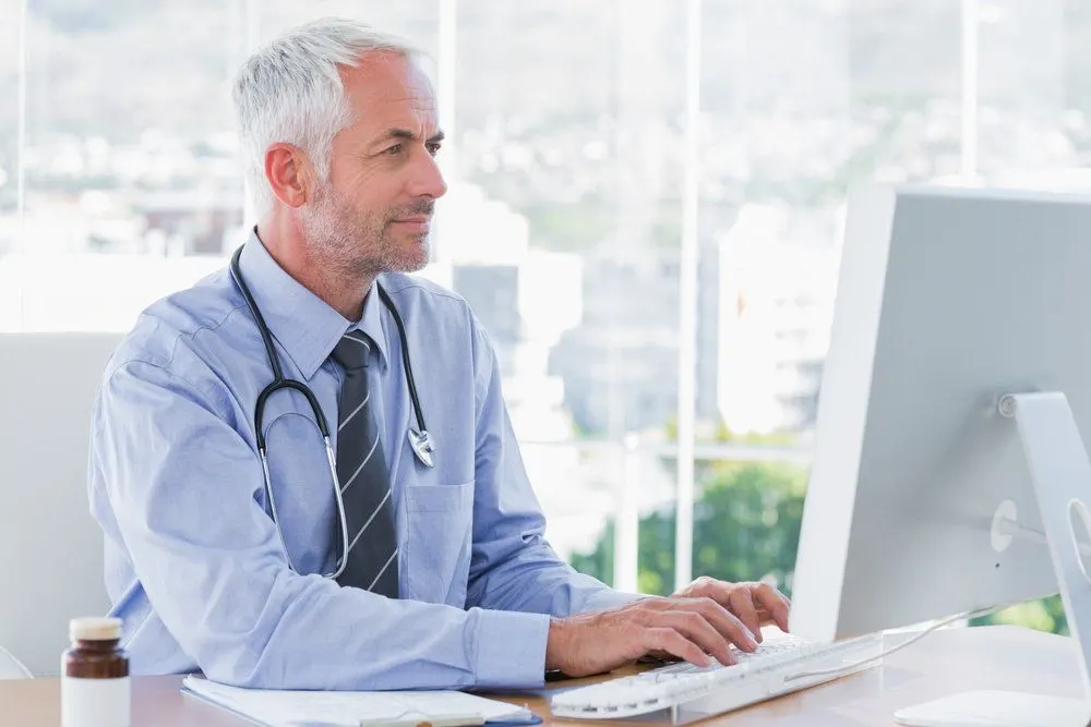 happy Doctor typing on his computer