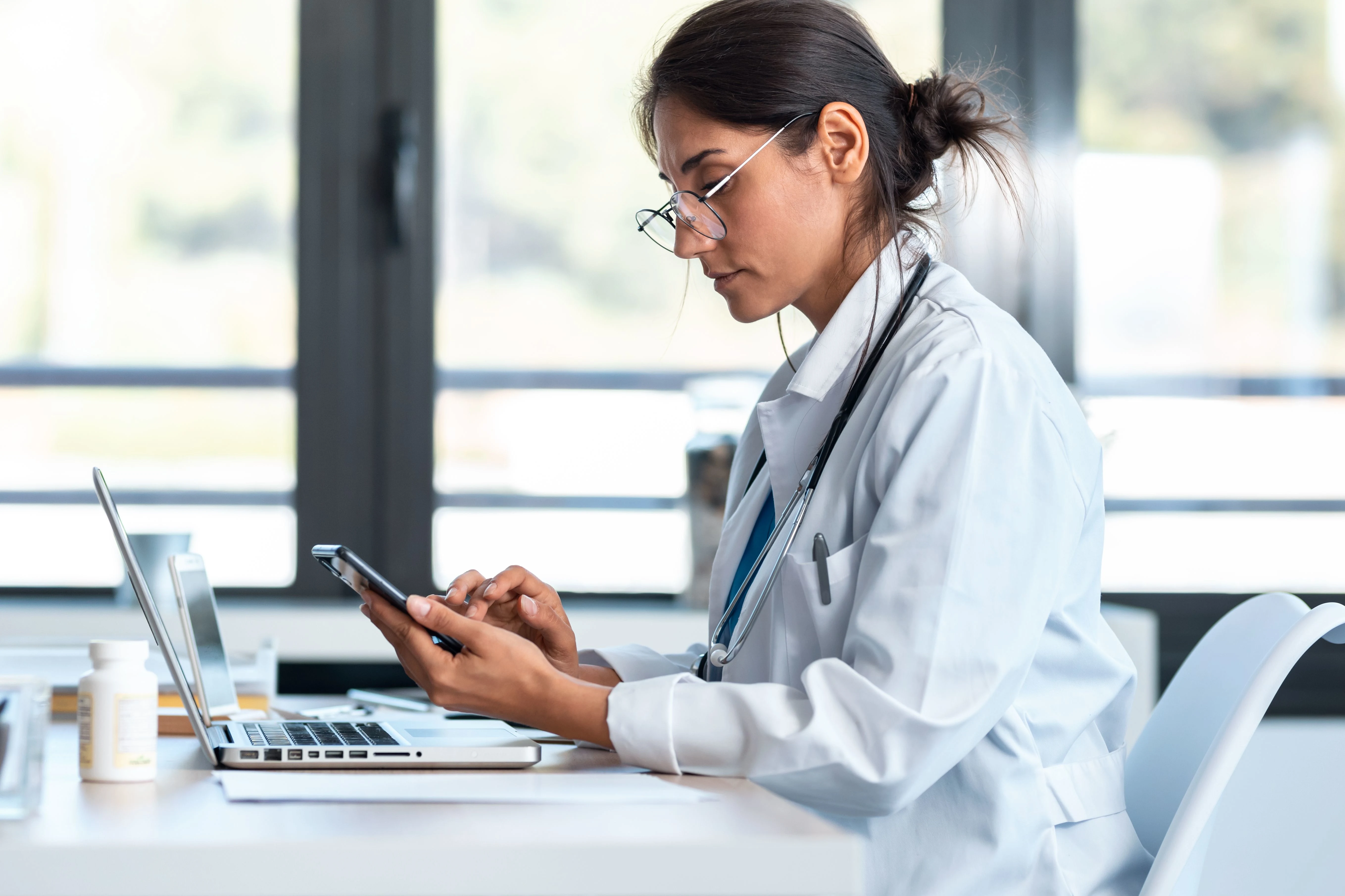 doctor working on phone and laptop