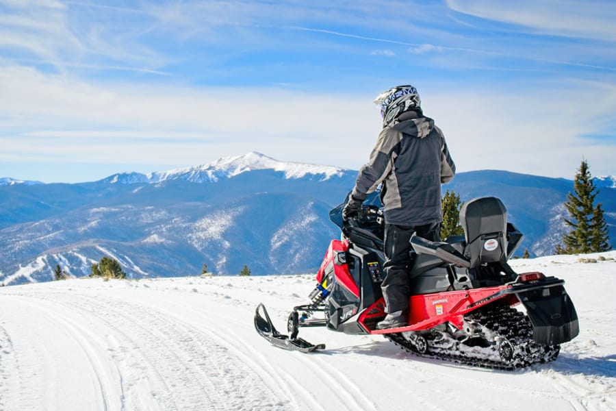 snowmobile on hillside overlooking mountains