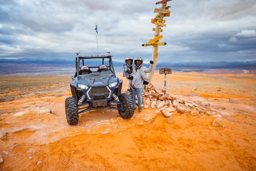 Polaris RZR and riders by directional sign in Utah