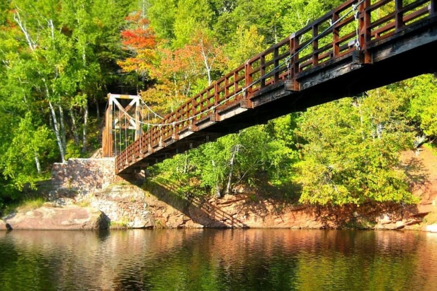 swinging bridge covering a river along an off-road trail
