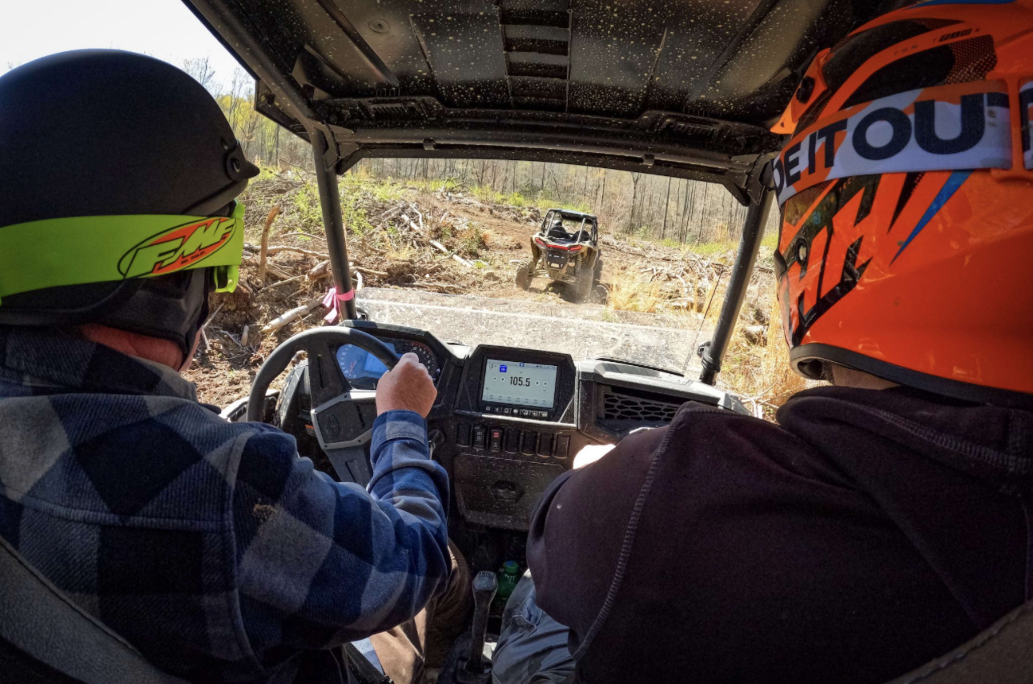 Two people in a Polaris RZR from driver's perspective.