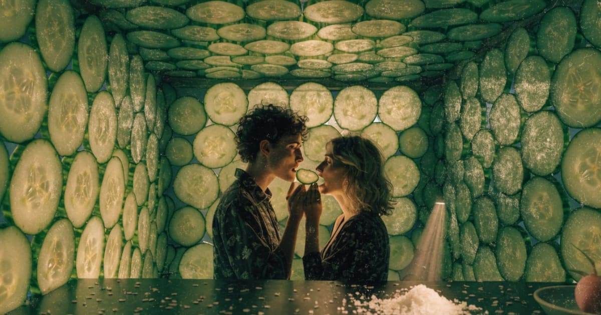 Vintage collage jade cucumber-glass grotto with thin translucent slices forming paned walls and ceiling, moonlight refracting green-gold, couple feeding each other hand to mouth at grotto center