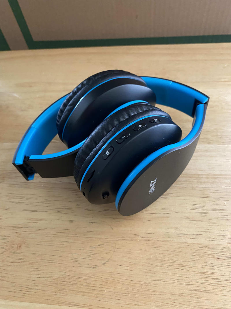 An aerial view of the headphones. The headphones are black with blue details and cushion.