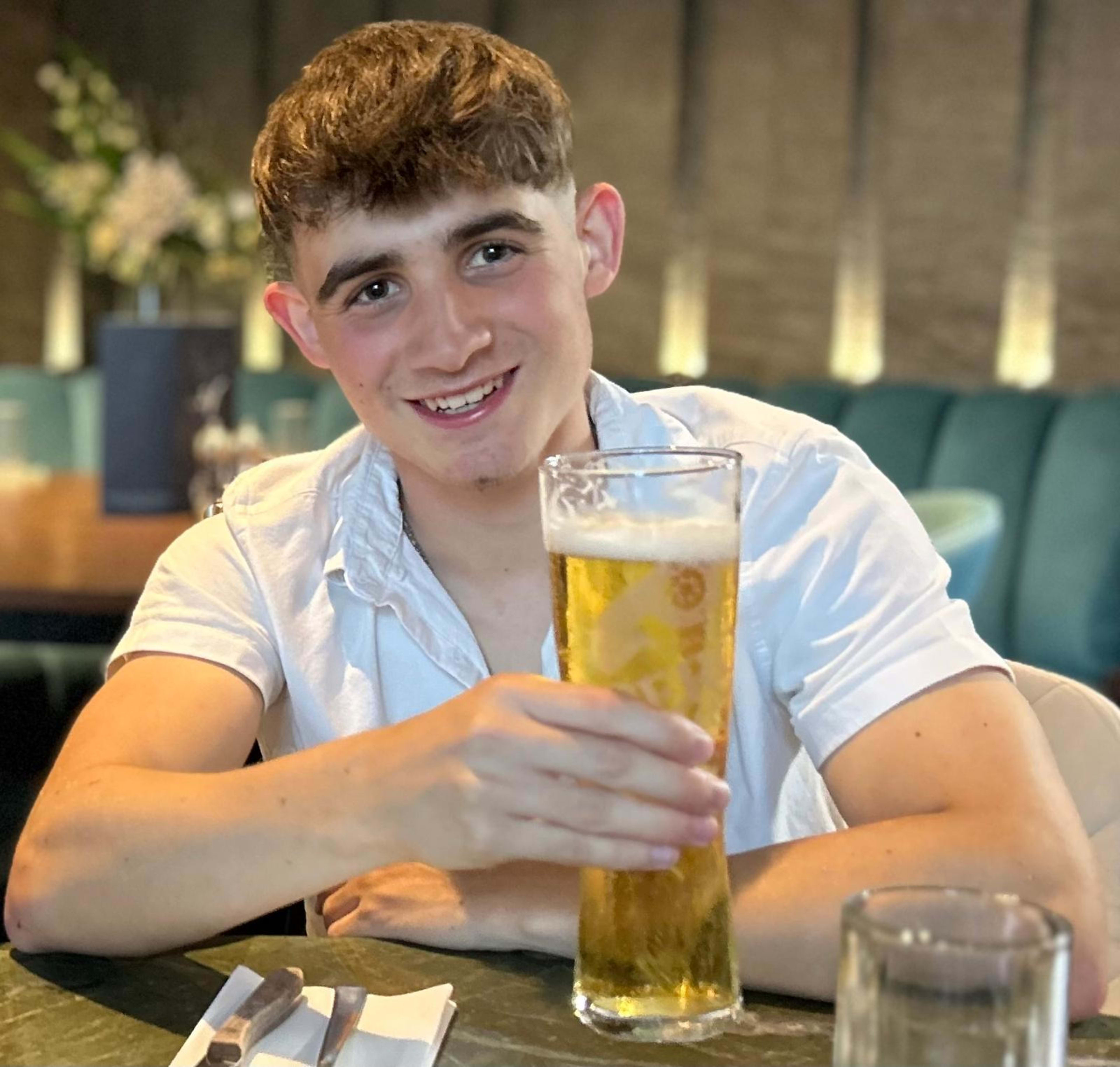 Charlie holding a beer, smiling