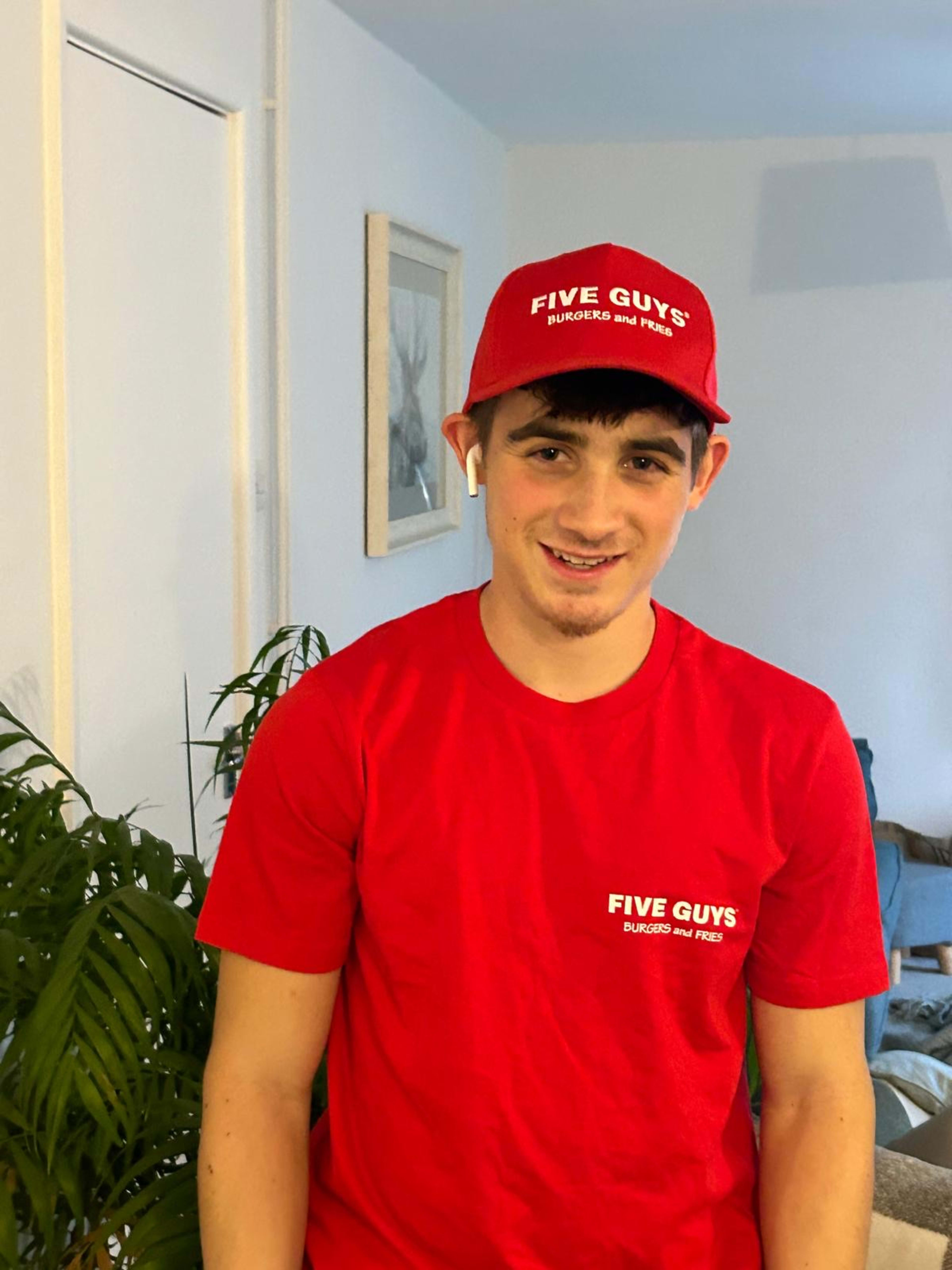 Charlie in Five Guys cap and t-shirt, AirPods in