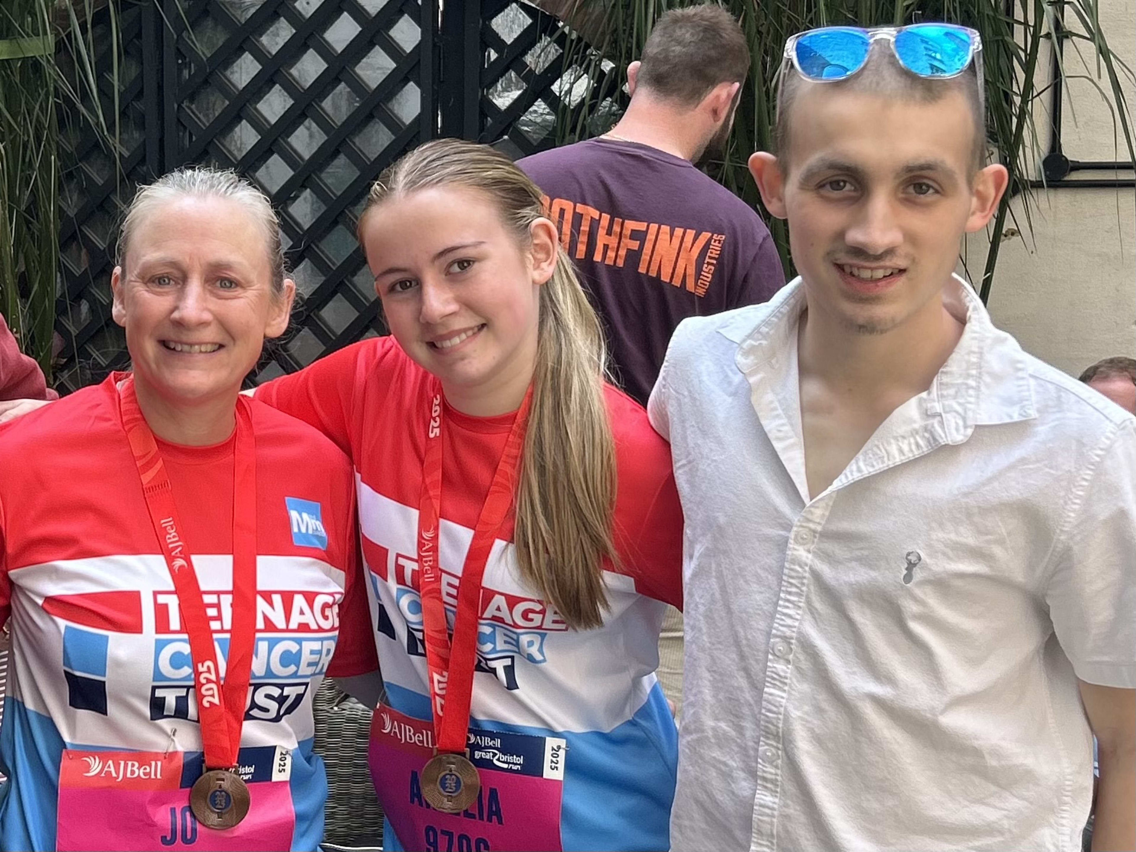 Jo and Amelia in Teenage Cancer Trust running vests with medals