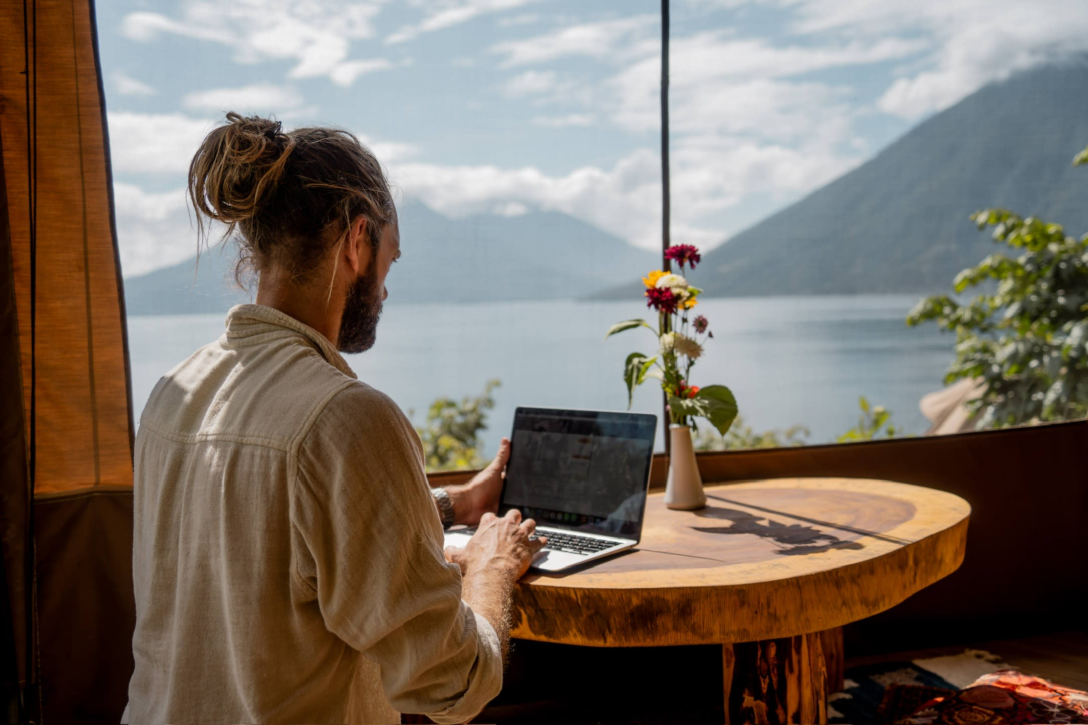Digital nomad working at Fuego Atitlán with lake and volcano view