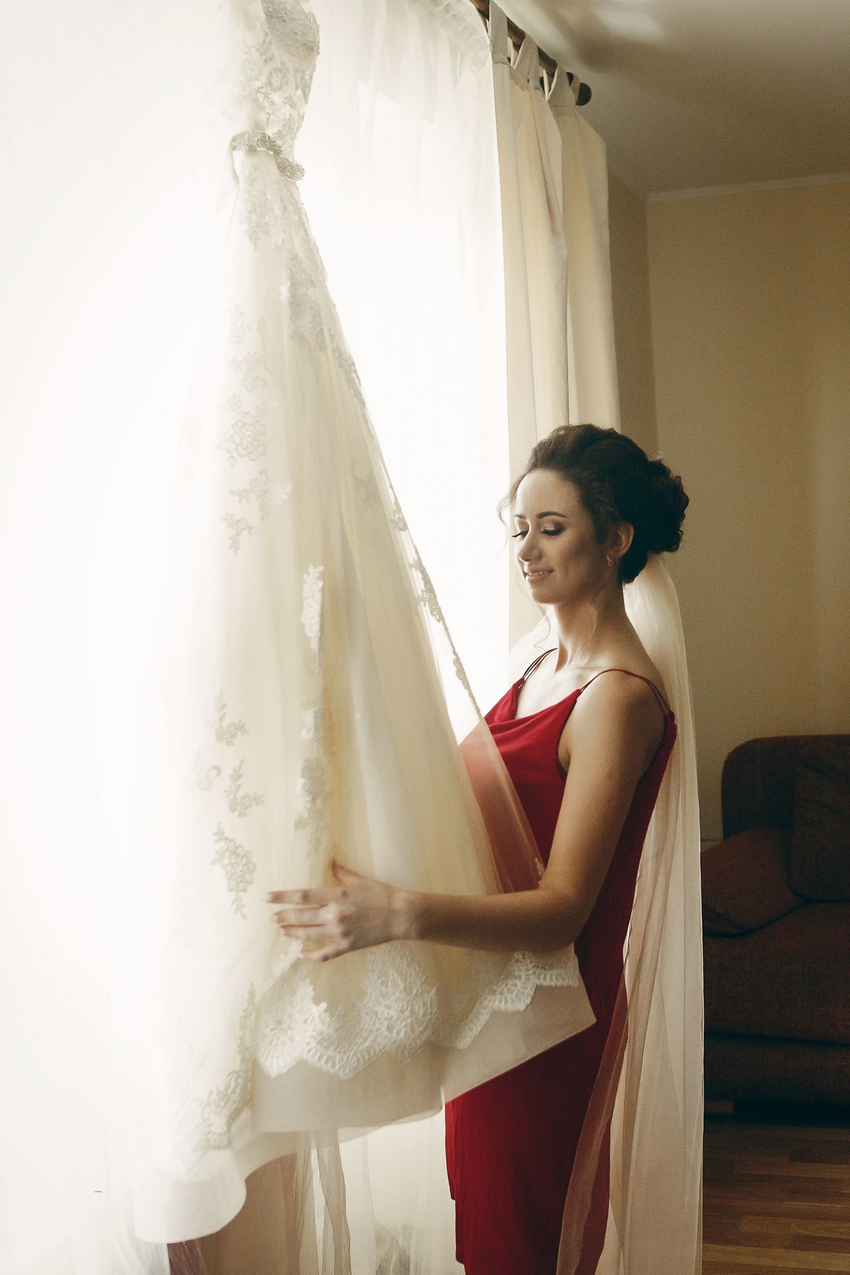 beautiful-bride-in-red-robe-with-veil-looking-at-e-2021-08-29-10-50-18-utc