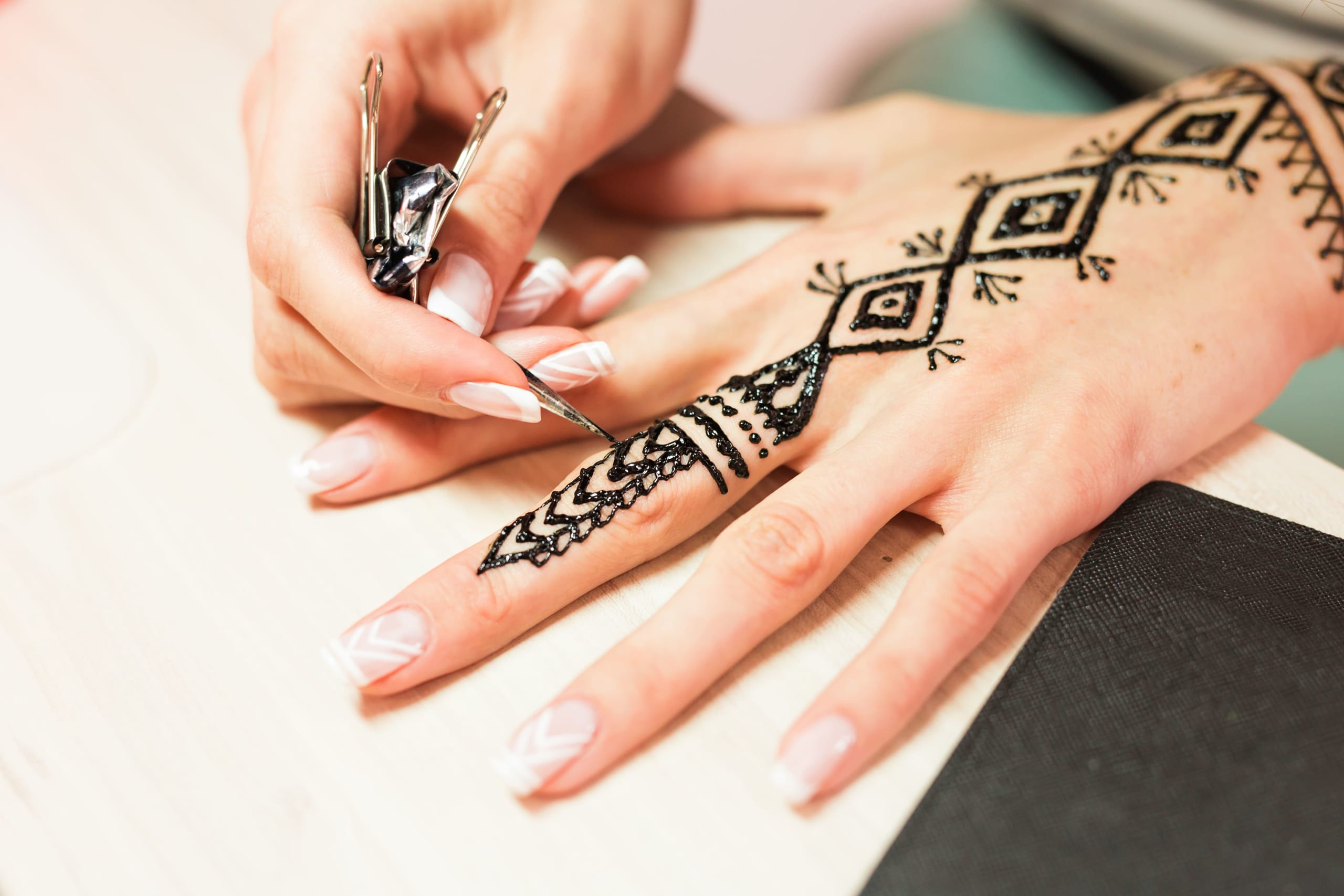 young-woman-mehendi-artist-painting-henna-on-the-h-2021-08-28-07-46-07-utc(1)