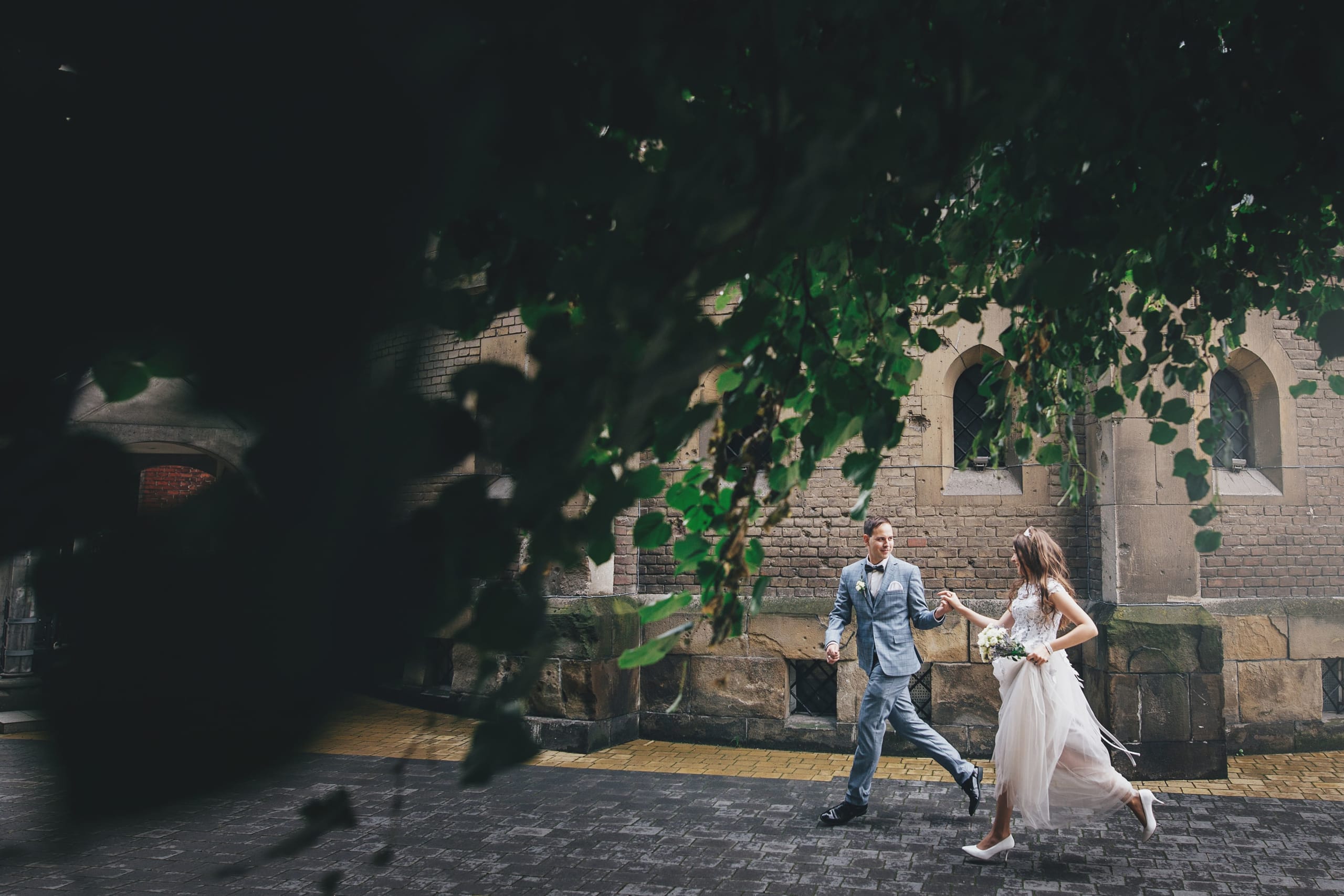 stylish-happy-bride-and-groom-running-and-smiling-2021-09-04-04-52-55-utc