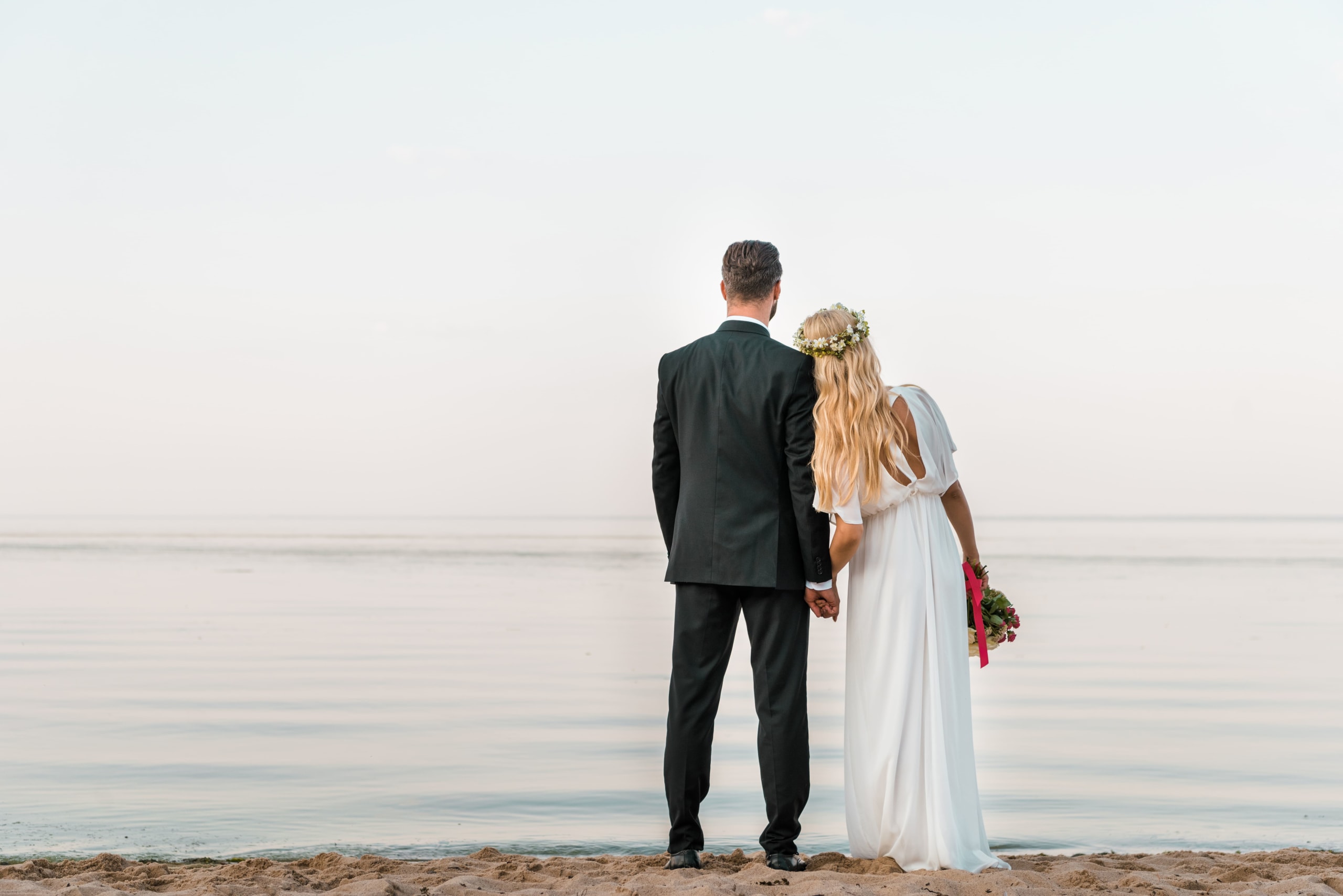 back-view-of-wedding-couple-standing-on-beach-with-2022-01-18-23-38-55-utc