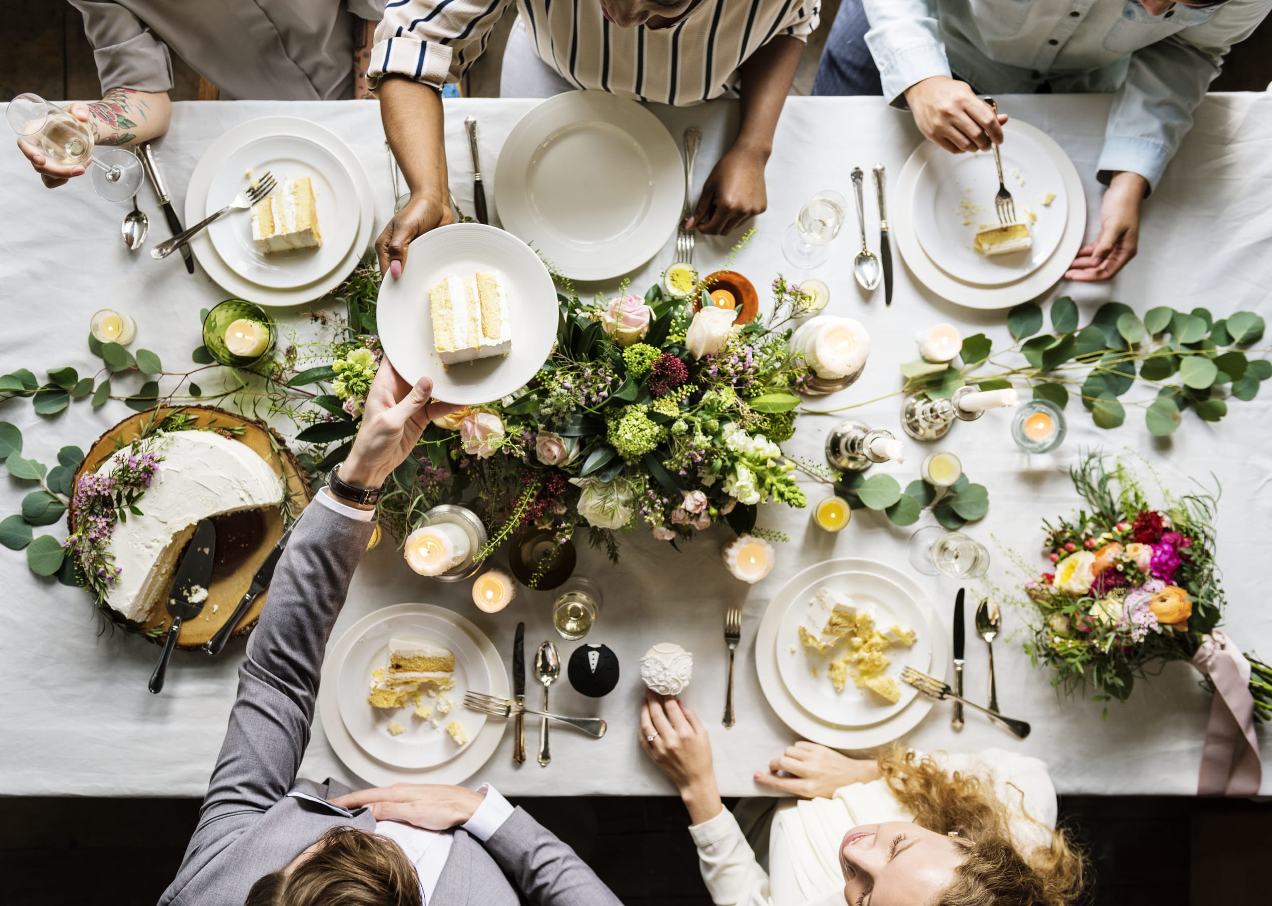 wedding-party-sharing-a-cake-at-a-table-2022-01-18-23-39-52-utc