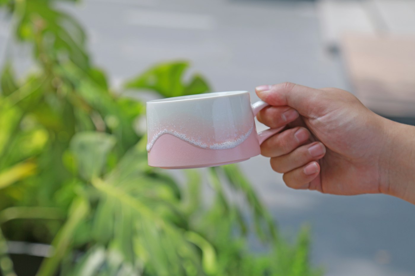 Hand holds a pink and white gradient wavy cup