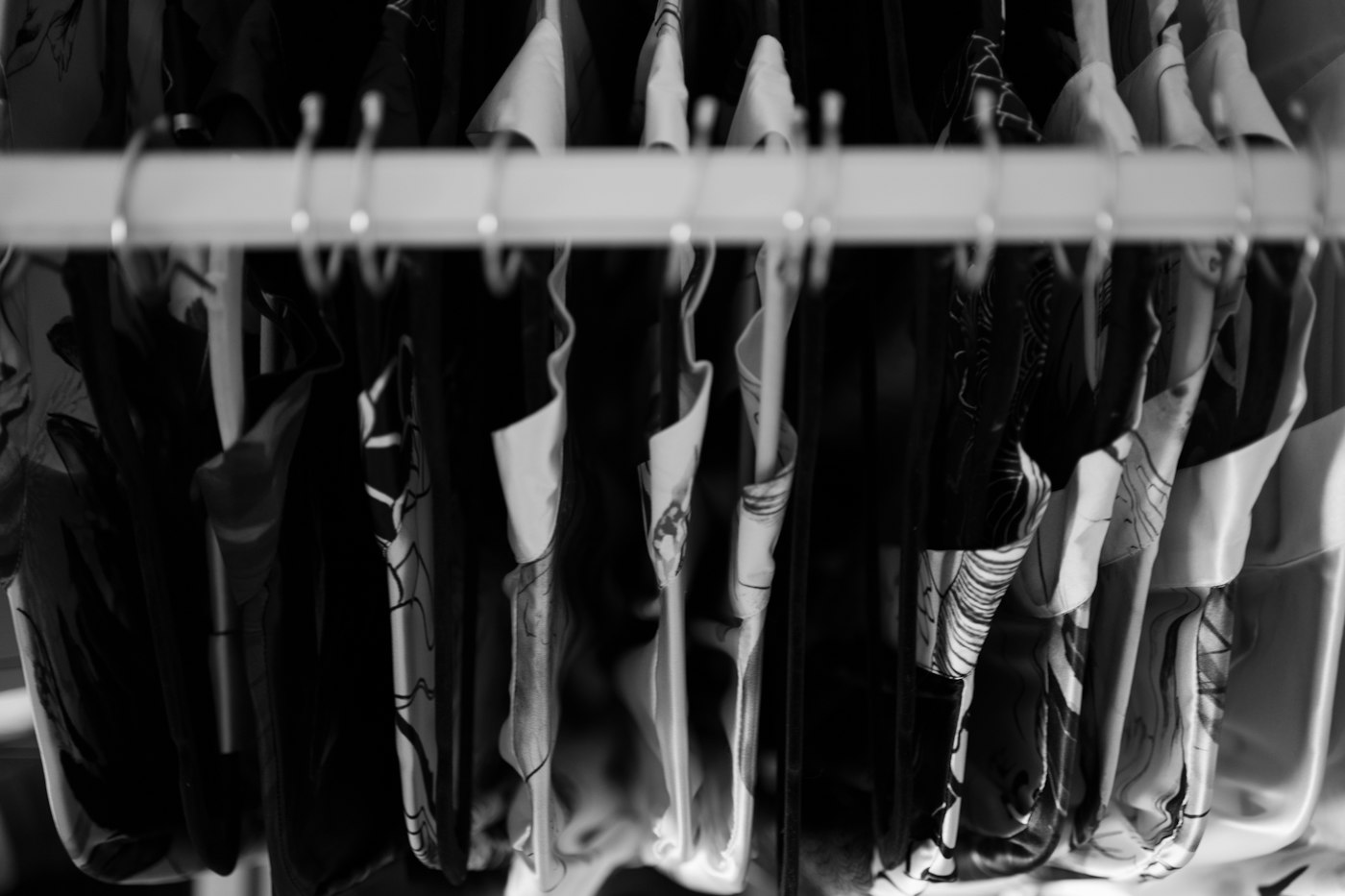 A bunch of umbrellas are hanging on a rack