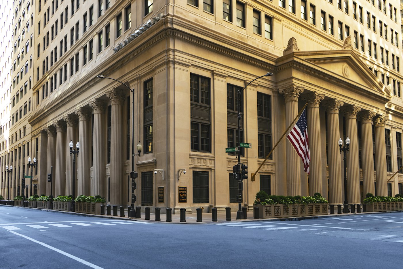a large building with columns and a flag on the corner