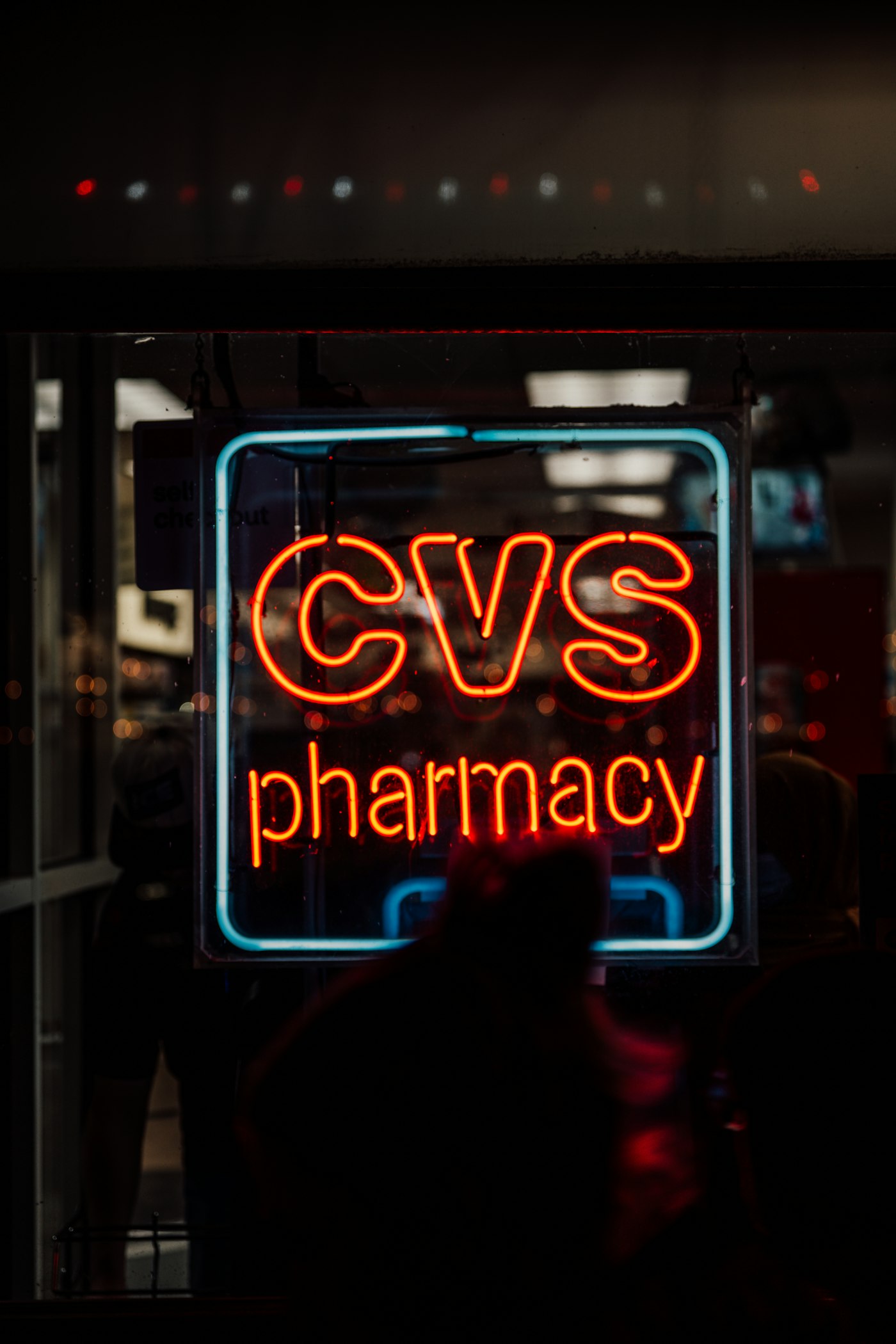 A neon cvs pharmacy sign glows at night