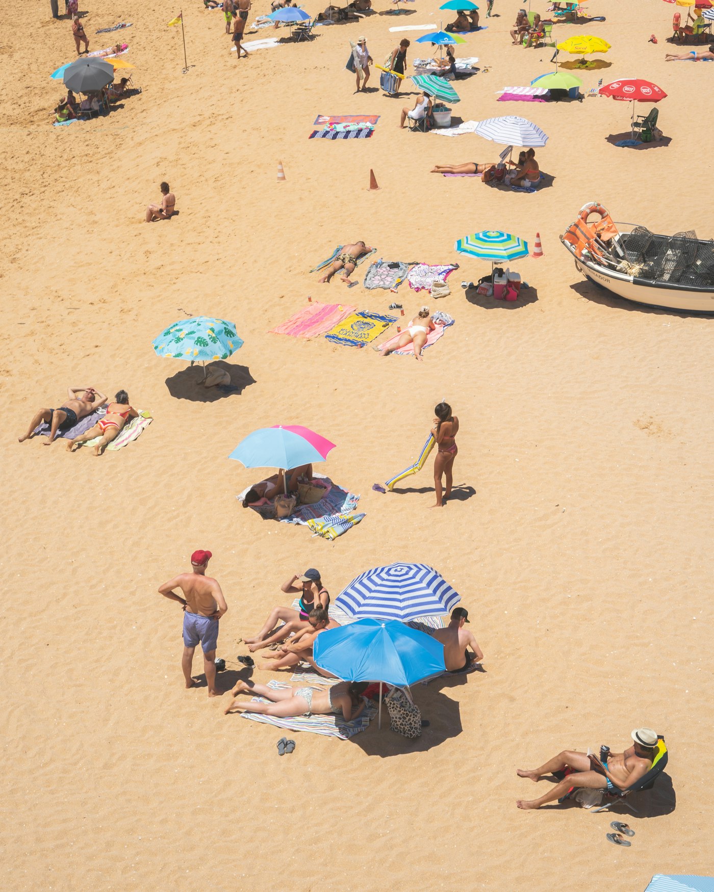 a crowded beach with many people and umbrellas