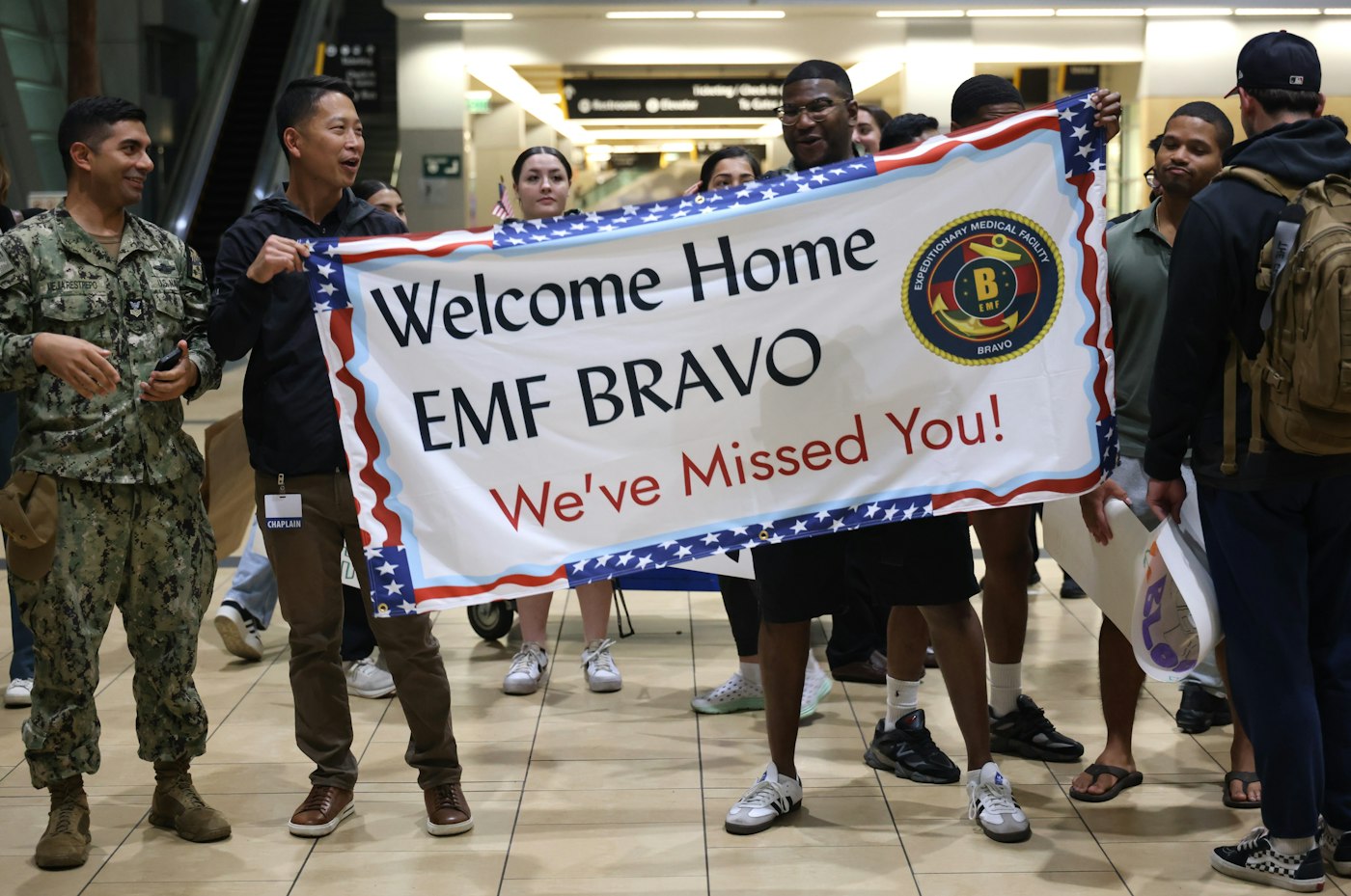People holding a welcome home banner for emf bravo