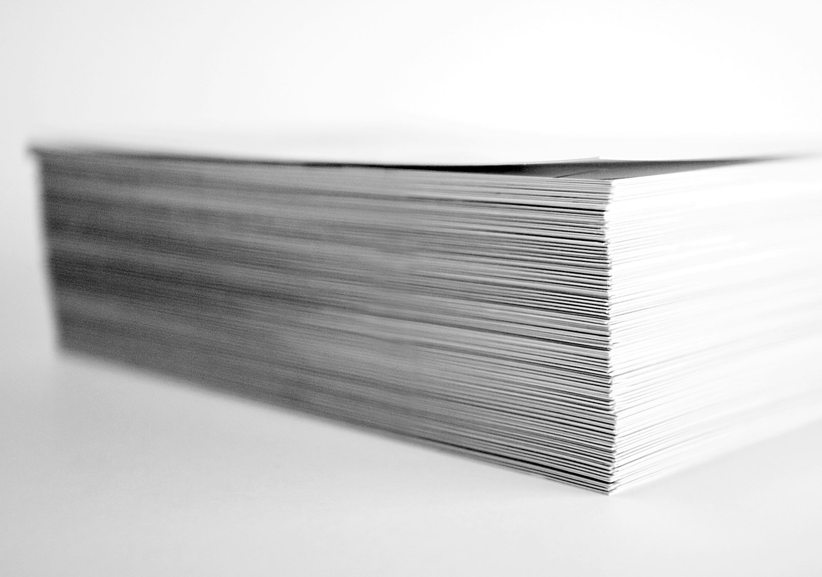 A thick stack of printed white paper on a desk