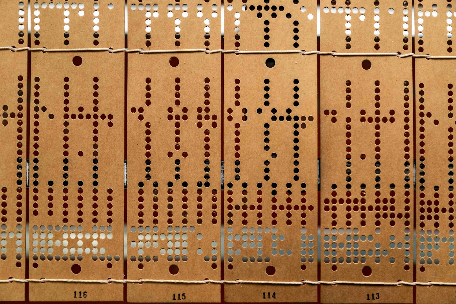 Rows of vintage punched cards showing holes that encode data