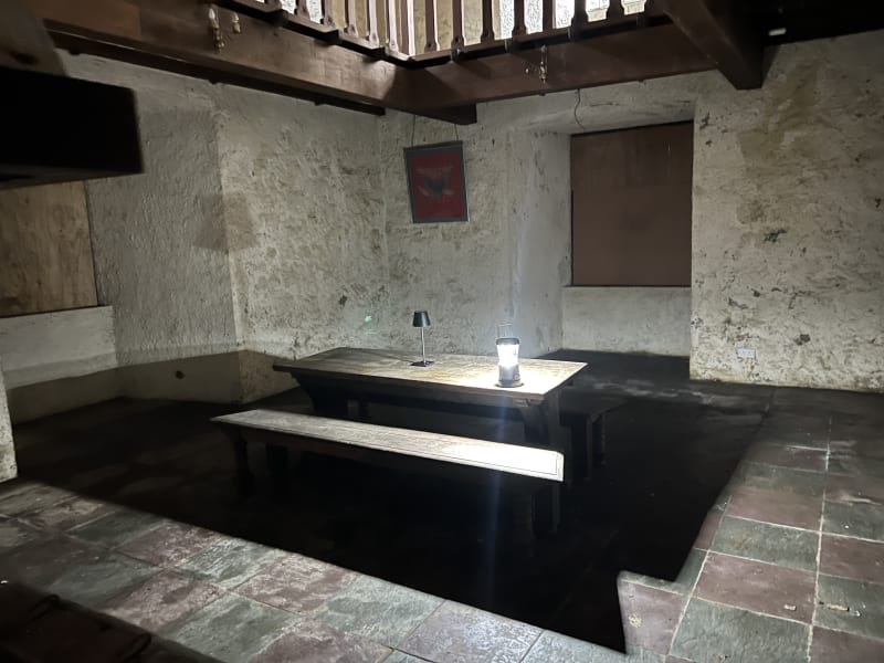 Wooden tables and benches beneath the upper gallery at Castle Matrix