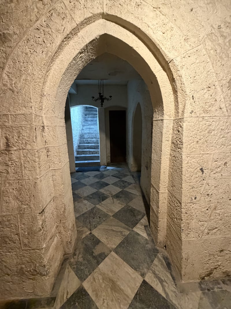 Pointed stone archway above a chequered castle floor
