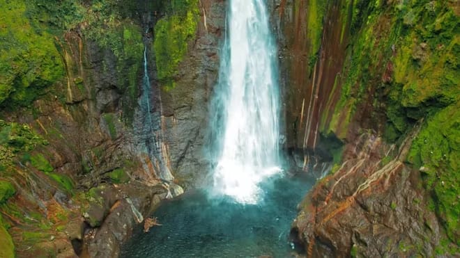 A powerful waterfall crashing into a river, representing the natural occurrence of Brown Noise.