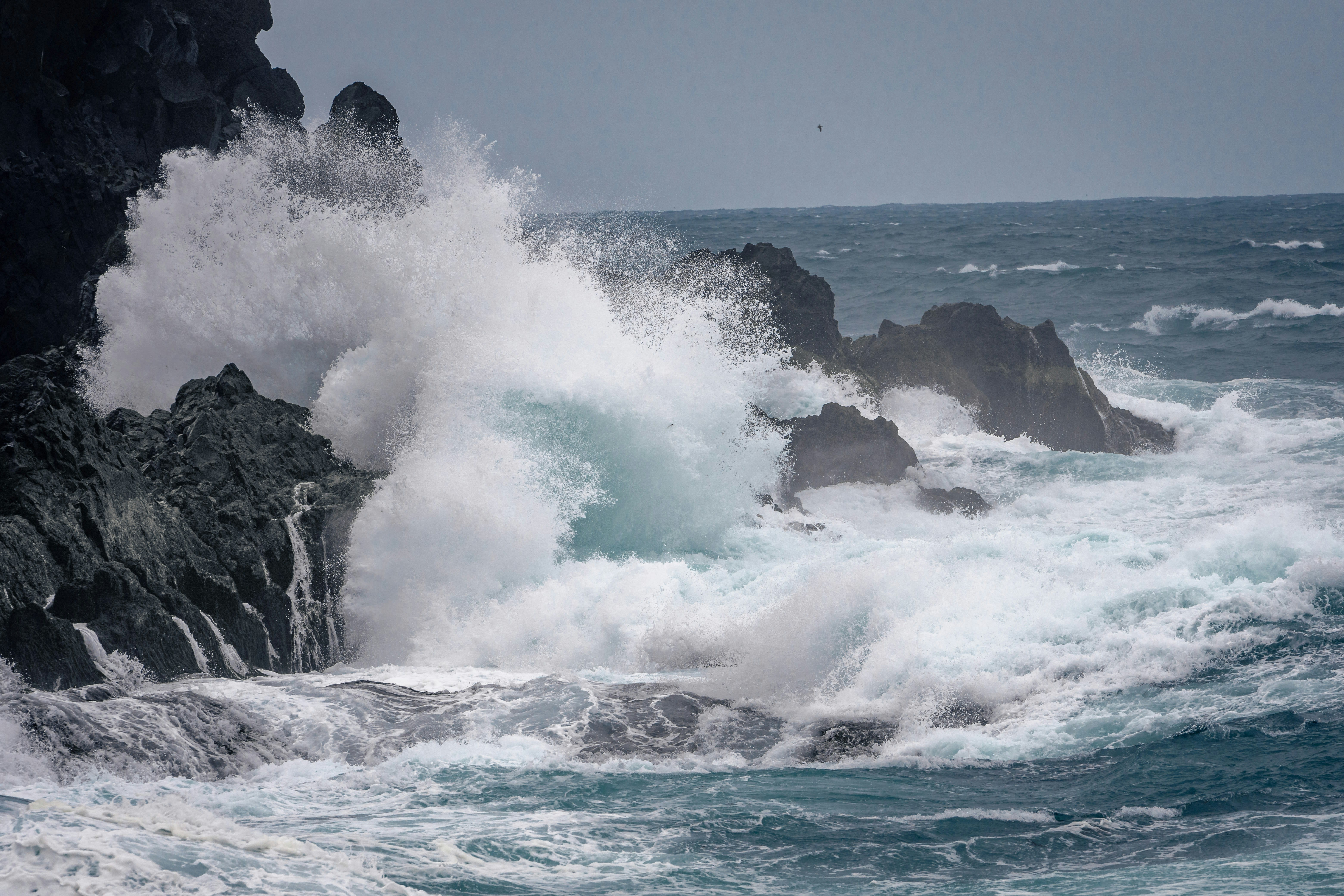 Gentle ocean waves hitting rocks, naturally creating a sound similar to brown noise.