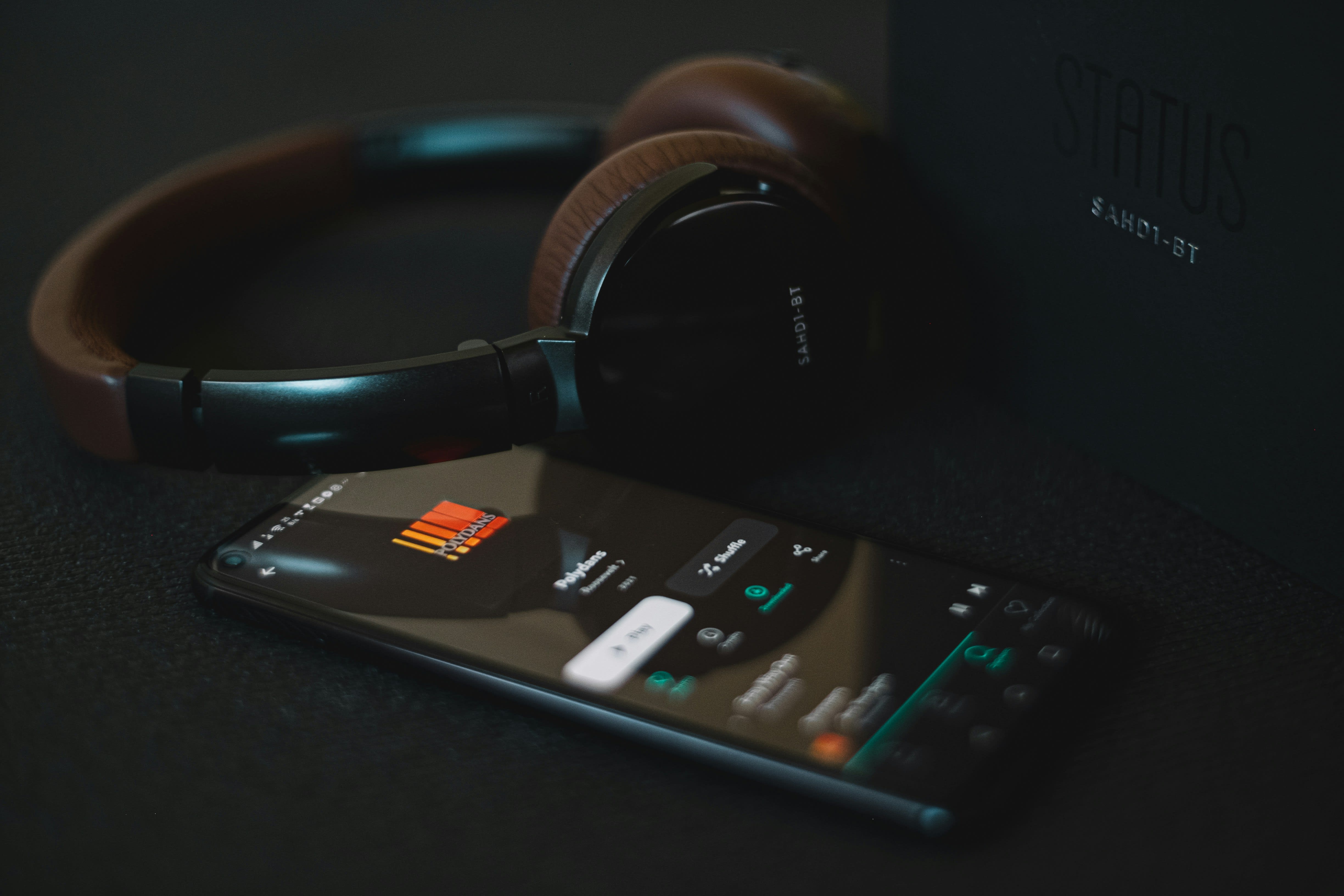 Headphones next to a smartphone running a sound app for playing brown noise.
