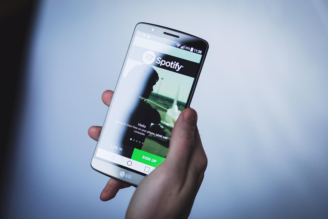 Person Listens to music with Spotify App. Spotify like many other online streaming platforms uses AAC audio format for its songs.