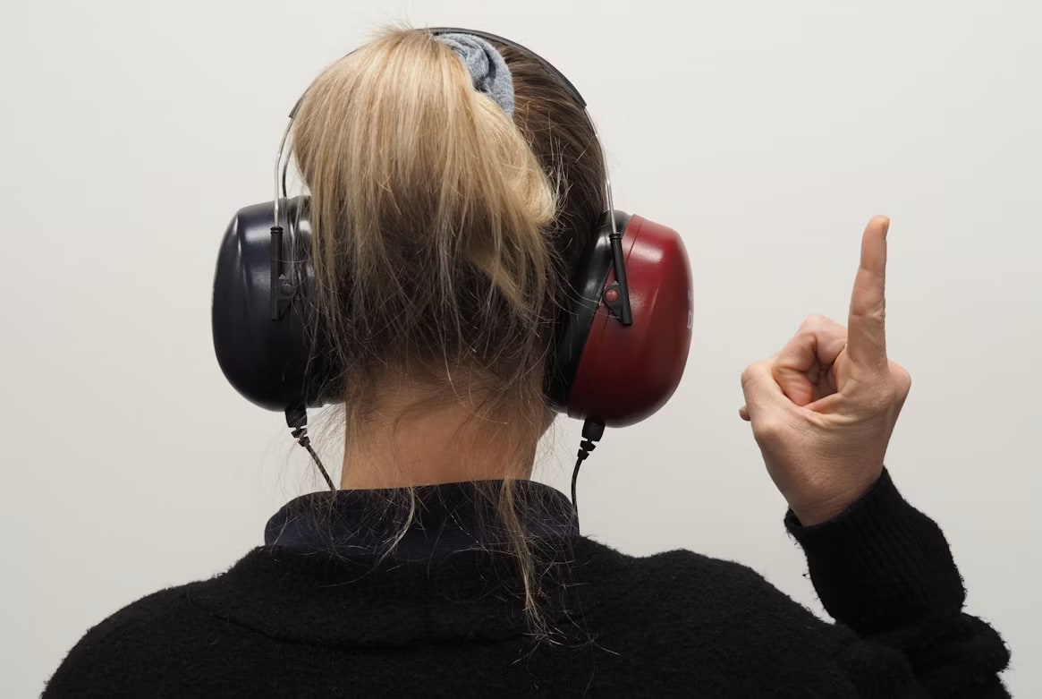 Image of Woman telling what she heard with headphone in Hearing Exam.
