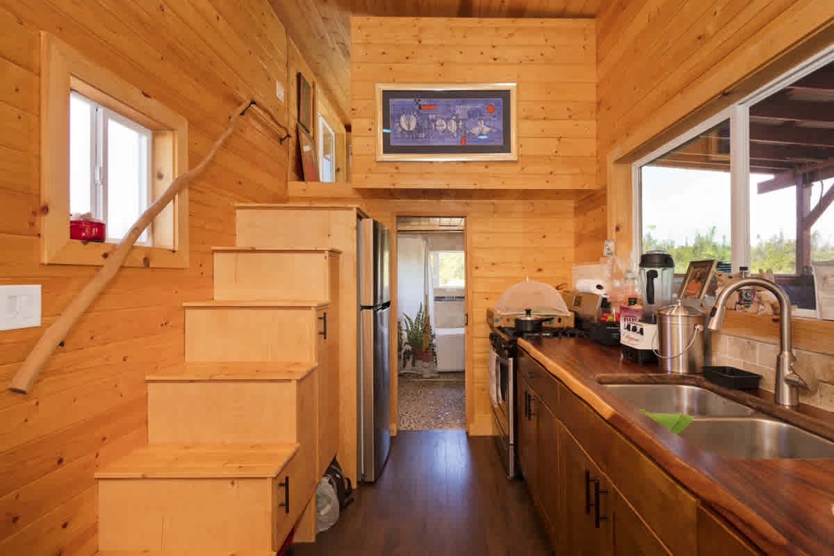 Kitchen with new energy saving full size appliances and lots of storage, facing towards bathroom and master sleeping loft