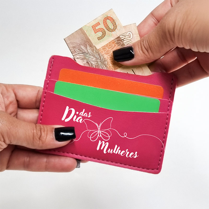 mãos retiram dinheiro de uma carteira na cor pink