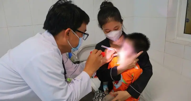 Phụ huynh nên đưa trẻ đi khám kịp thời khi xuất hiện sốt, nốt loét miệng và ban đỏ tay chân. Ảnh: Hoàng Lộc