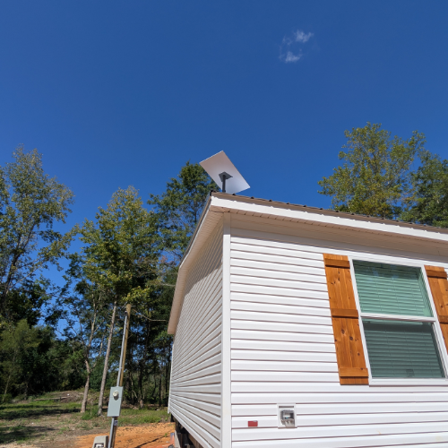 Satellite dish mounted on a pole in a yard
