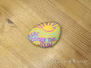 Painted painting stone by artist nad_doodles showing sayings. Here comes the sun ☀️.