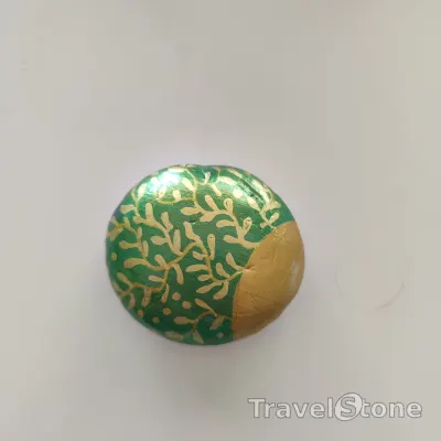 Painted painting stone by artist CJ showing pattern. Gold green painted TravelStone.
