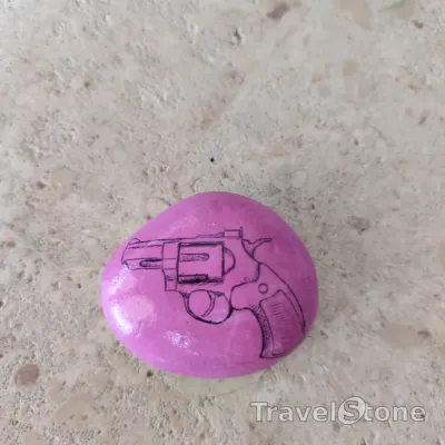 Painted painting stone by artist CJ showing fantasy. Gun Power TravelStone.