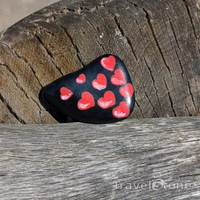 Painted painting stone by artist 007 showing fantasy. It's raining hearts.