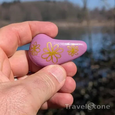 Painted painting stone by artist CJ showing pattern. Flowers in gold on vontage pink.