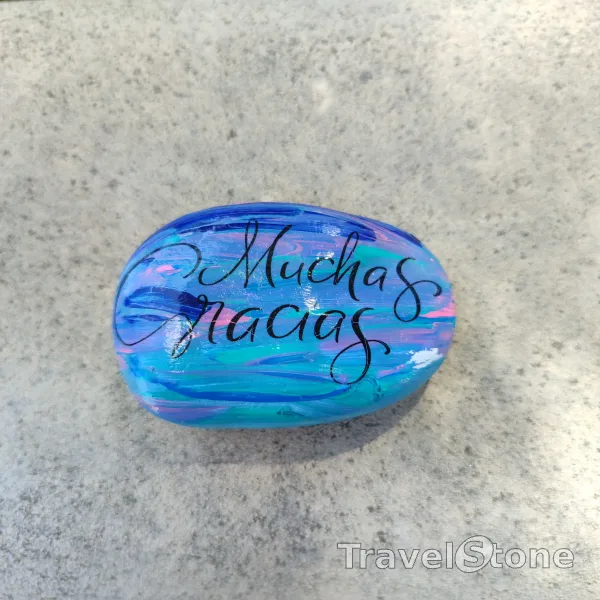 Painted painting stone by artist CJ showing sayings. Muchas Gracias TravelStone