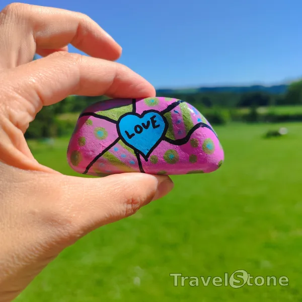 Painted painting stone by artist LaLiLu showing sayings. Purple green love TravelStone