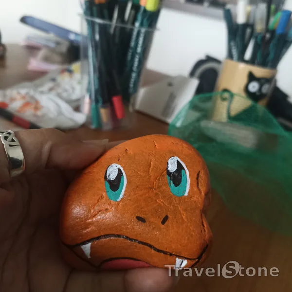 Painted painting stone by artist comfortinstones showing comic. Charmander (pretending to be)
