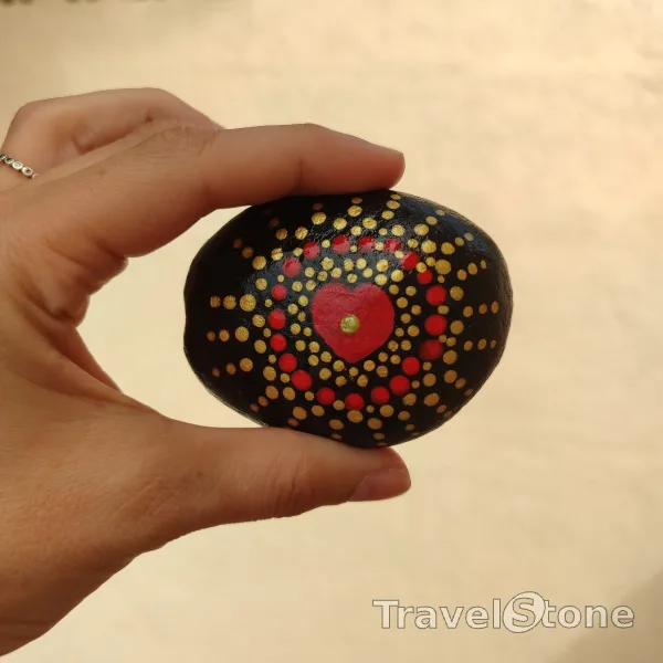 Painted dotting stone by artist CJ showing pattern. Mandala red/gold