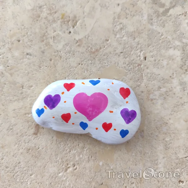Painted painting stone by artist CJ showing pattern. TravelStone with hearts