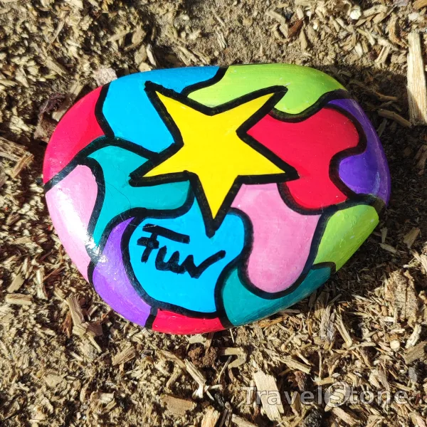 Painted painting stone by artist LaLiLu showing fantasy. Farbiger Stein auf Acrylbasis fotografiert auf rauem Holz