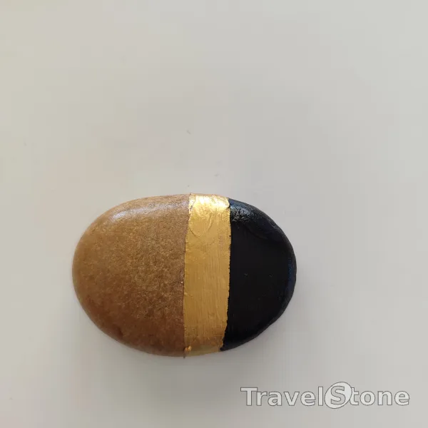 Painted painting stone by artist Ella showing pattern. Gold and black painted stone